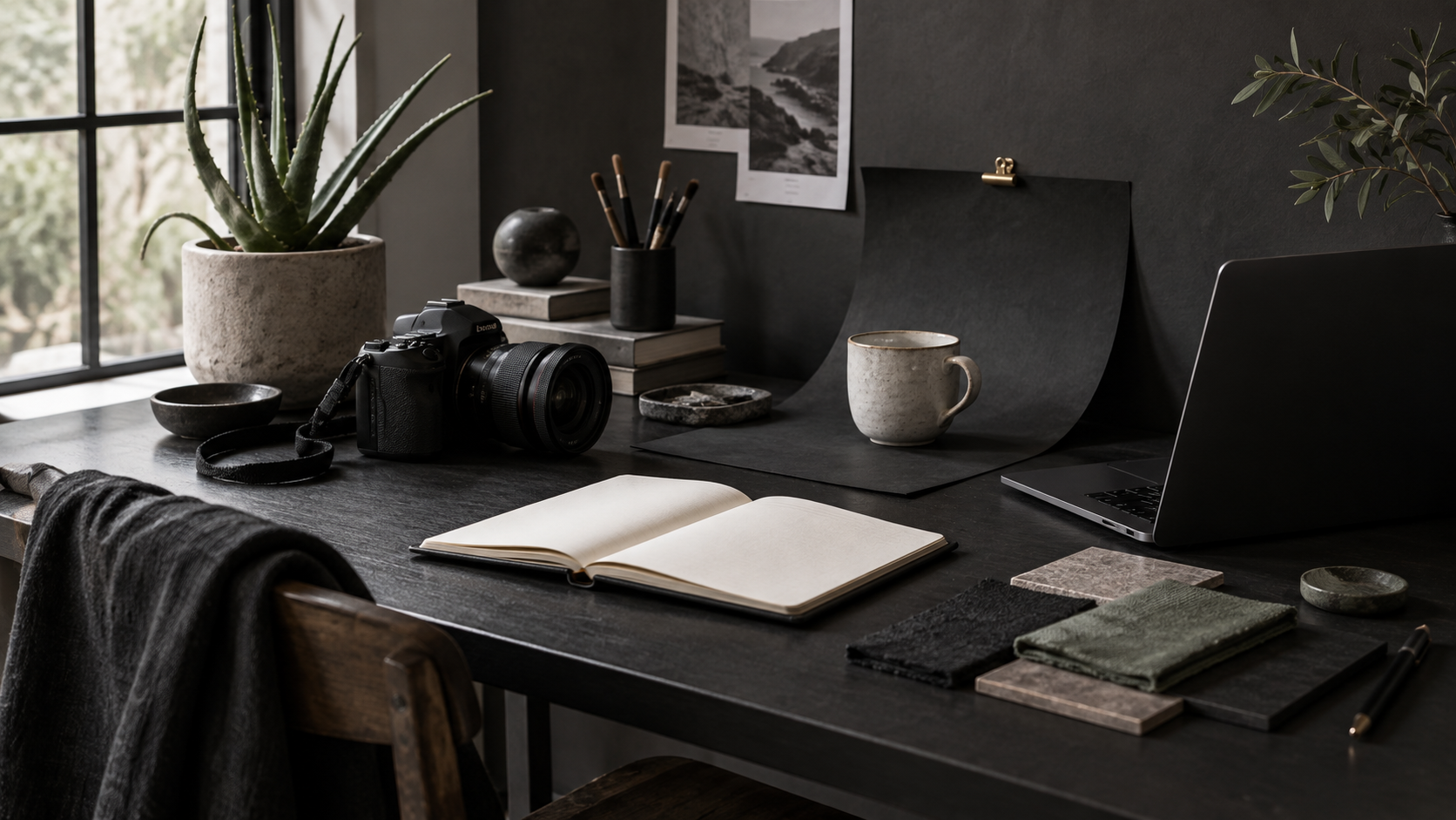 A photography and writing workbench with a camera, notebook and ceramic products.